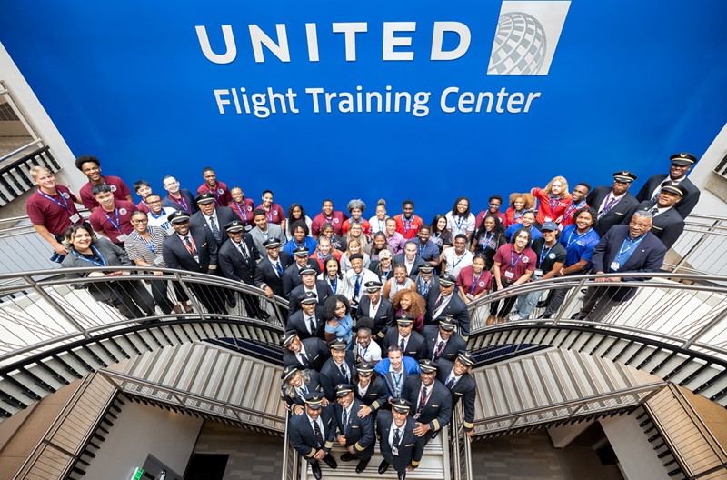 A group of United pilots and employees, as well as students from Historically Black Colleges and Universities, posing for an arial picture on the stairs in front of our United Flight Training Center logo as they celebrate HBCU Day.